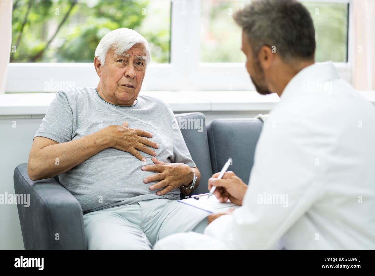 Der Ältere Patient Der Hauspflege Spricht Mit Seinem Arzt Stockfoto