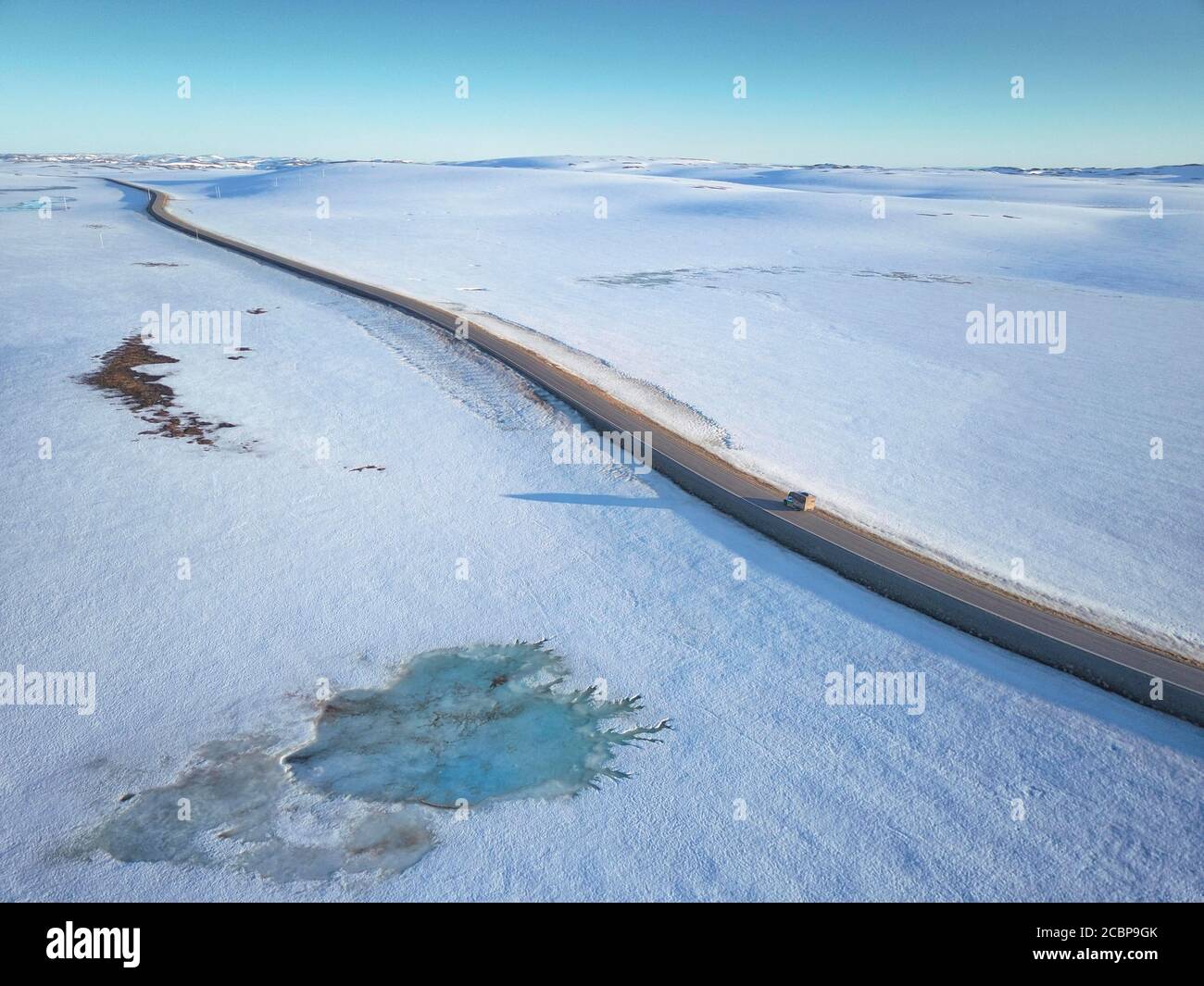 Einsame Straße zum Nordkap in schneebedeckter arktischer Landschaft mit Wohnmobil, Finnmark, Norwegen Stockfoto