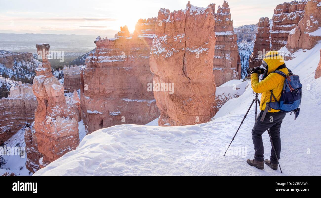 Touristen fotografieren, Felsformation Thors Hammer, Morgenlicht, Sonnenaufgang, bizarre verschneite Felslandschaft mit Hoodoos im Winter, Navajo Loop Trail Stockfoto