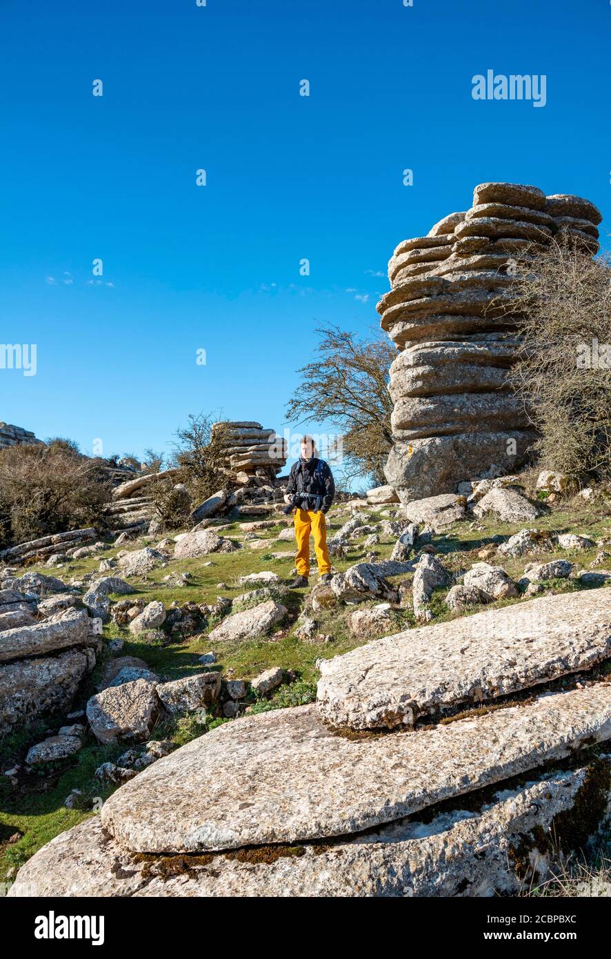 Junger Mann auf Felsen, Kalksteinformationen, El Torcal Naturschutzgebiet, Torcal de Antequera, Provinz Malaga, Andalusien, Spanien Stockfoto