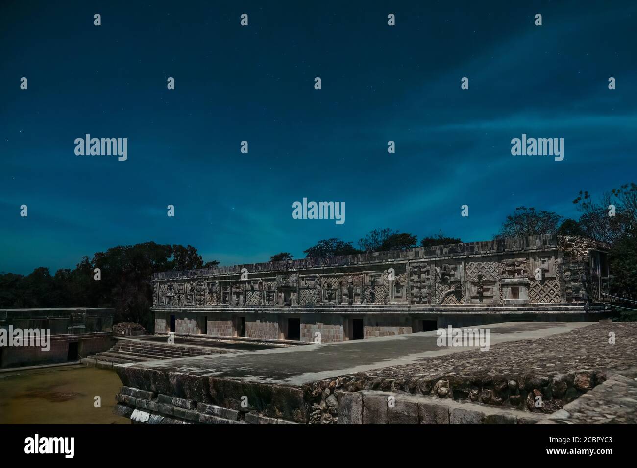 Das westliche Gebäude des Nunnery Quadrangle wird vom Mond in den prähispanischen Maya-Ruinen von Uxmal, Mexiko, erleuchtet. Stockfoto