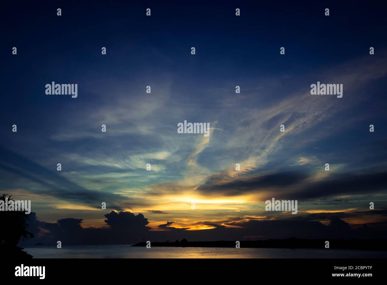 Meer bei Sonnenuntergang mit bewölktem Himmel Stockfoto