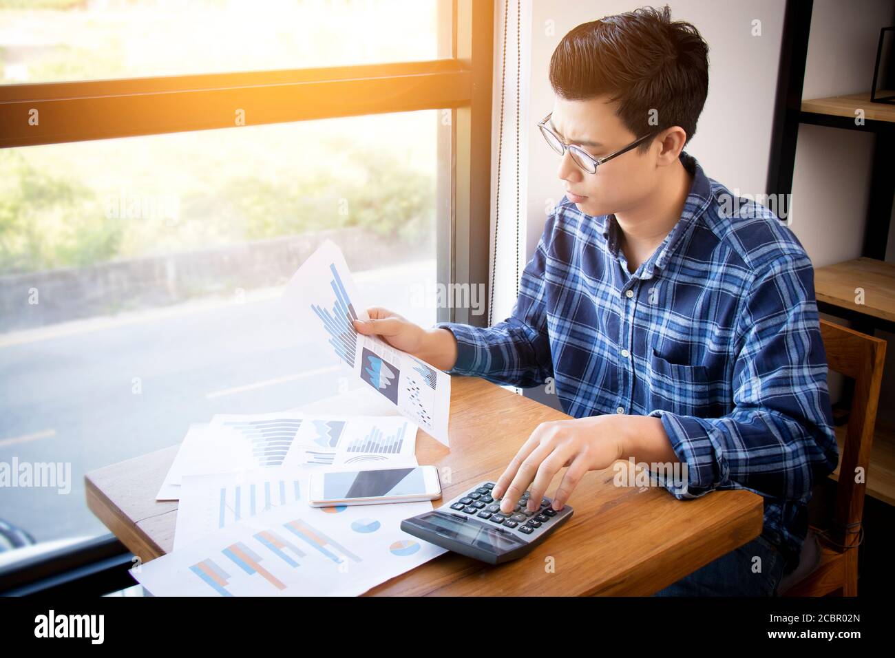 Business Accounting Menschen, Sparen, Finanzen und Wirtschaft Konzept. Serious Asian Geschäftsmann mit Taschenrechner für Berechnungen Dokumente, Diagramme Stockfoto