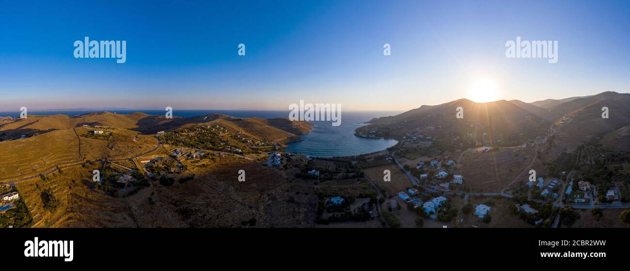 Kea Tzia Insel, Kykladen, Griechenland. Panorama der Bucht von Otzias bei Sonnenaufgang. Sonne, die im Morgengrauen hinter den Hügeln aufgeht, ruhiges Wasser, Luftaufnahme von der Drohne Stockfoto