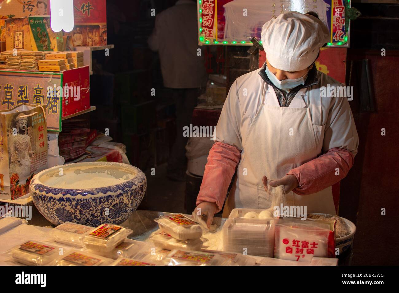 Luoyang, Provinz Henan / China - 3. Januar 2016: Weibliche Köchin bereitet Mehlnudeln in einem Straßenverkäufer-Restaurant in Luoyang, China, zu Stockfoto
