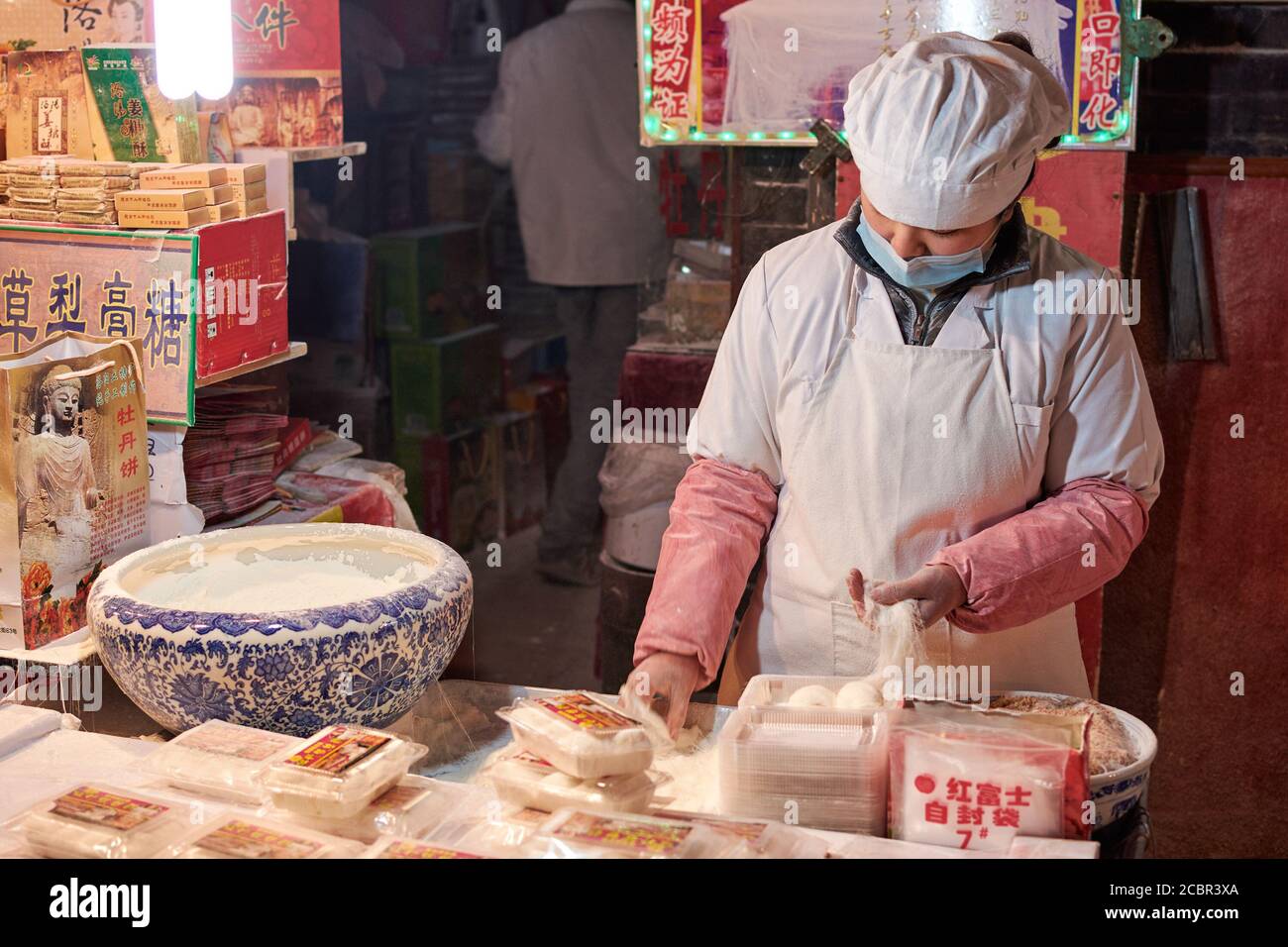Luoyang, Provinz Henan / China - 3. Januar 2016: Weibliche Köchin bereitet Mehlnudeln in einem Straßenverkäufer-Restaurant in Luoyang, China, zu Stockfoto