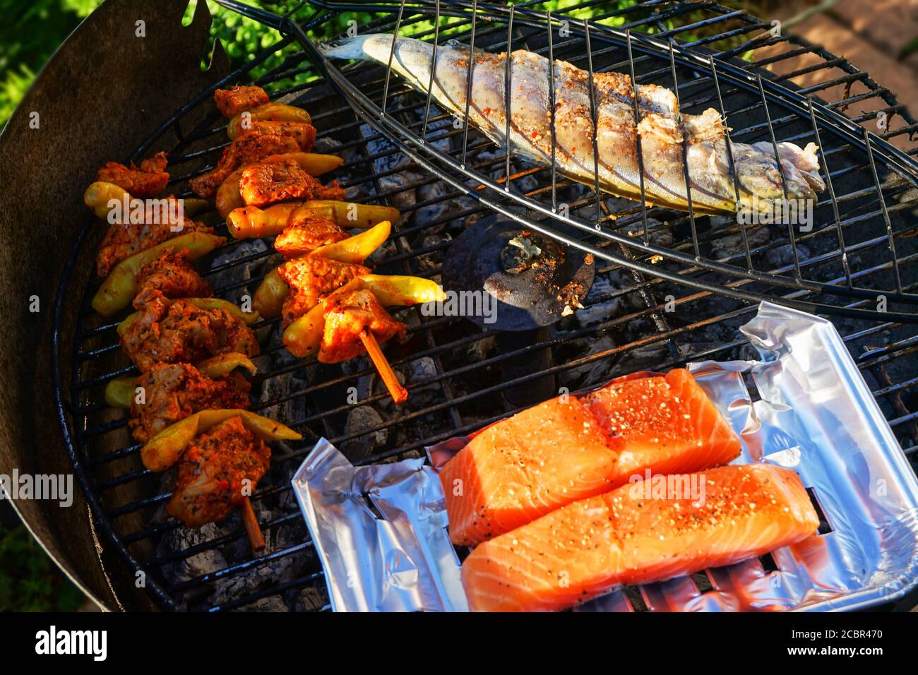 Fisch, Lachs und Hähnchenspieß auf dem Grill Stockfoto