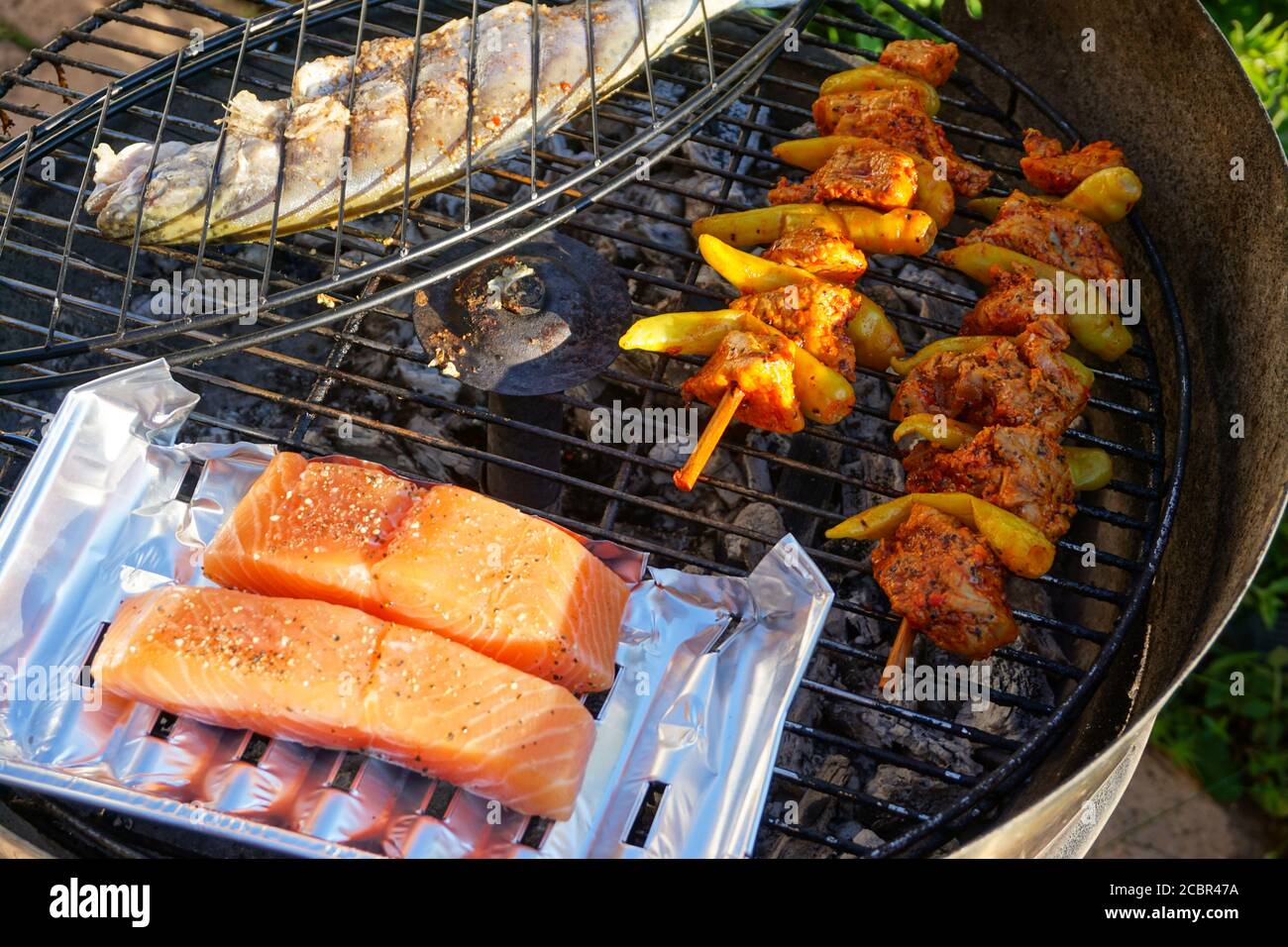 Fisch, Lachs und Hähnchenspieß auf dem Grill Stockfoto