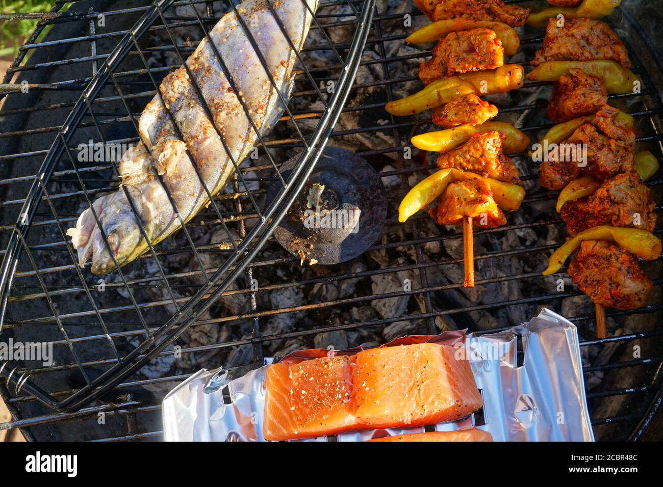 Fisch, Lachs und Hähnchenspieß auf dem Grill Stockfoto