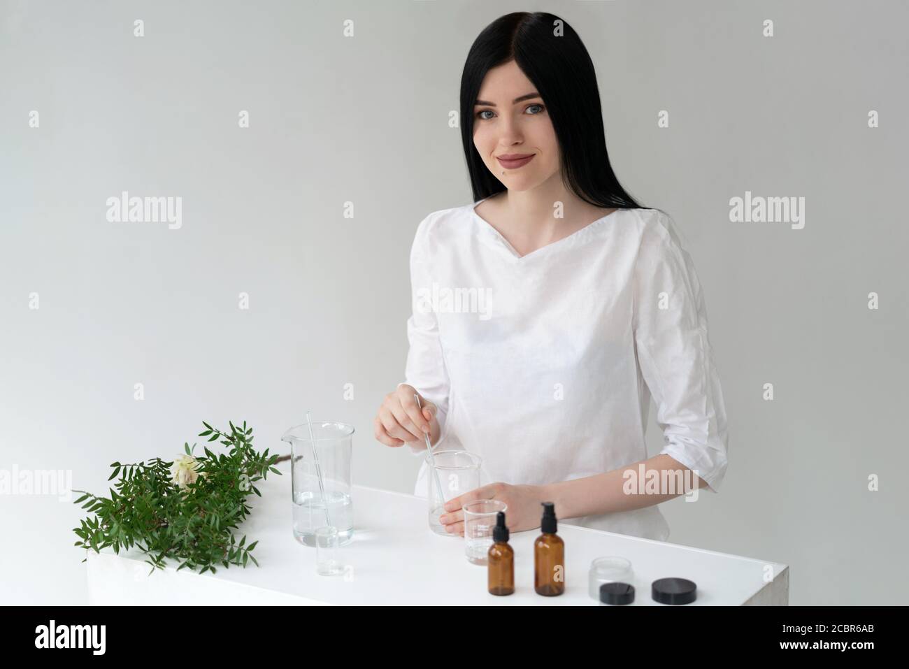 Der Wissenschaftler, Dermatologe testet das organische Naturkosmetikprodukt im Labor. Fläschchen, Laborflaschen aus Glas. Kosmetische Forschung Stockfoto