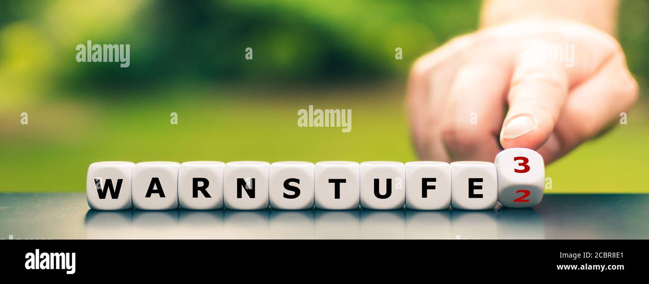 Würfel bilden den deutschen Ausdruck 'Warnstufe 3' (Warnstufe 3). Benachrichtigung bei Unwetter. Stockfoto