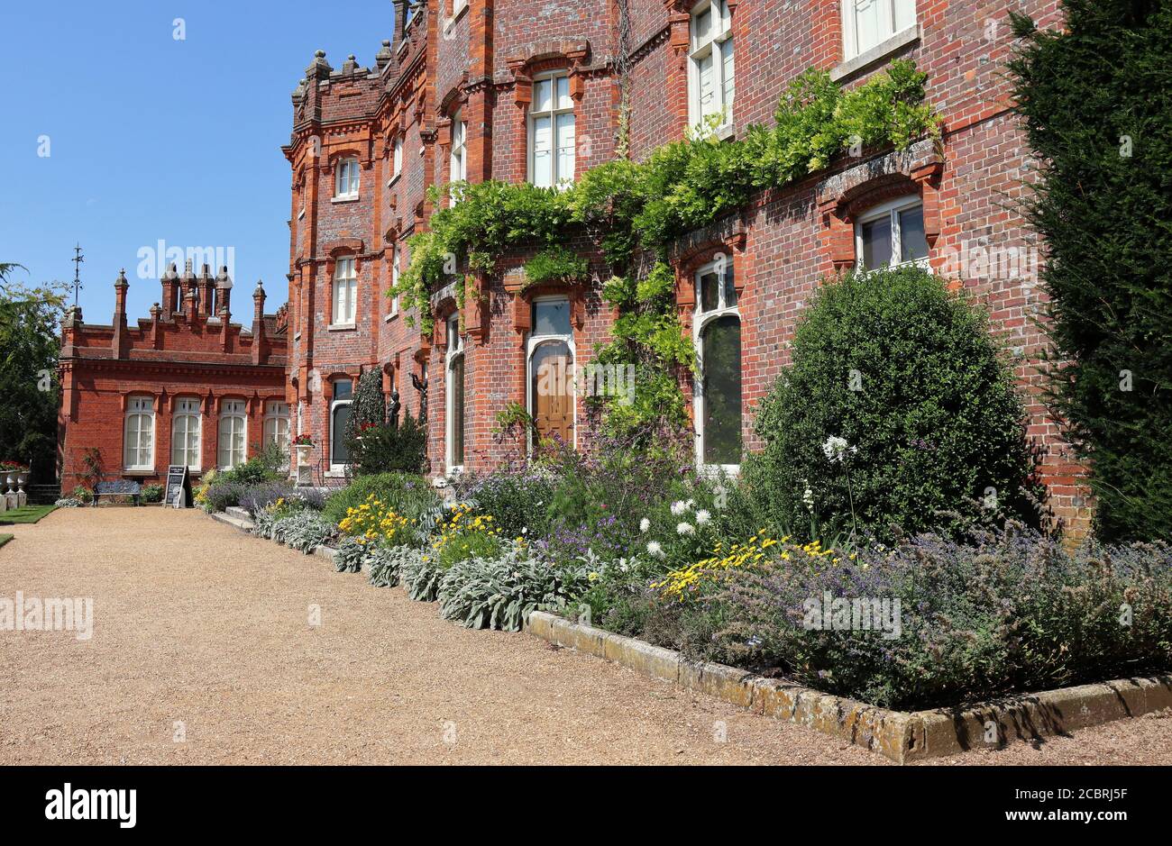 Ein englisches Herrenhaus mit buntem Blumenbeet vorne Stockfoto
