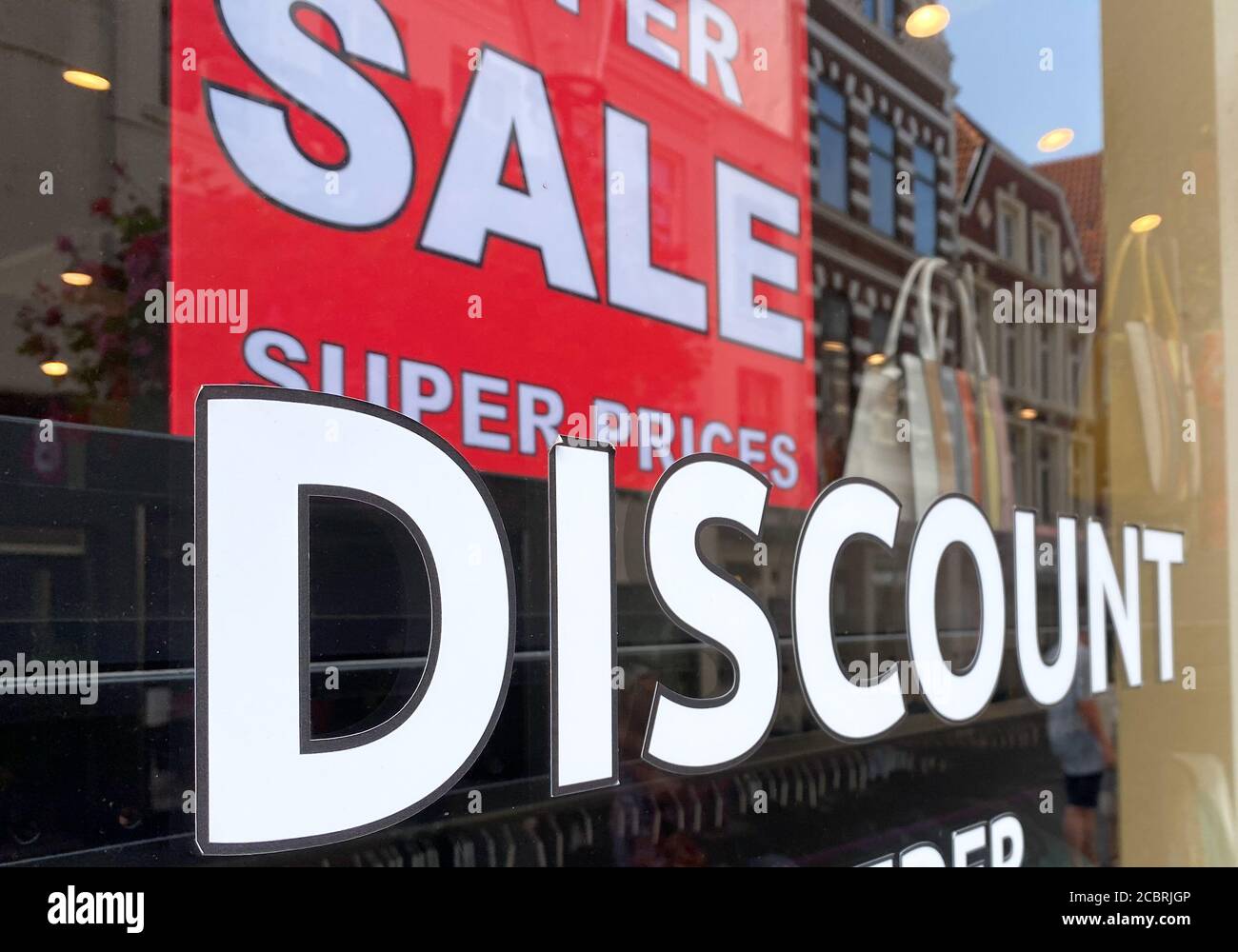 Venlo, Niederlande - 9. Juli. 2020: Blick auf Schaufenster mit Zeichen für Rabatt, Verkauf, super Preis. (Schwerpunkt auf Buchstabe 'D') Stockfoto