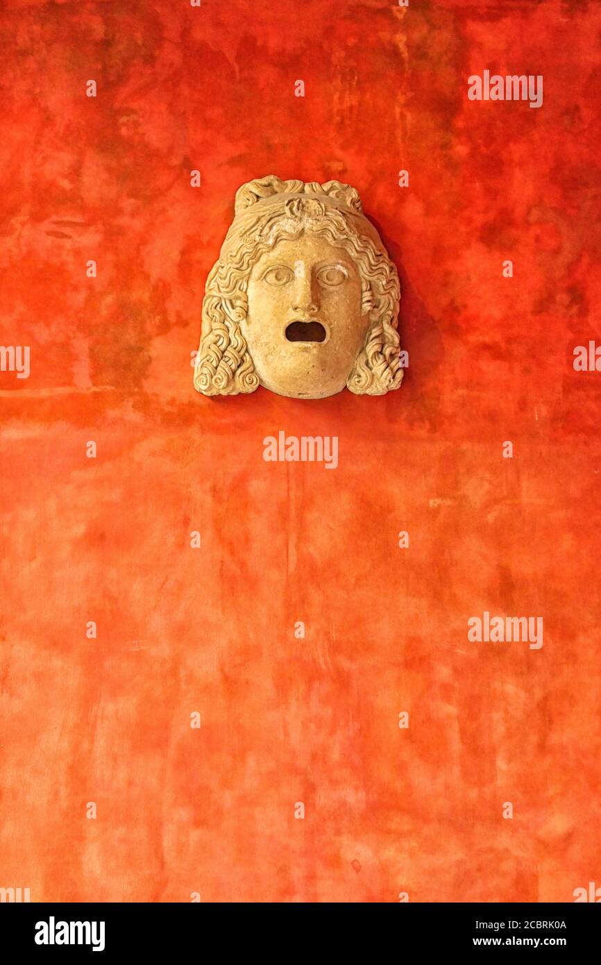 Steingesicht der Frau an einer leuchtend orangefarbenen Wand. Antiker römischer Kopf im Museum Glyptotek in Kopenhagen, Dänemark Stockfoto
