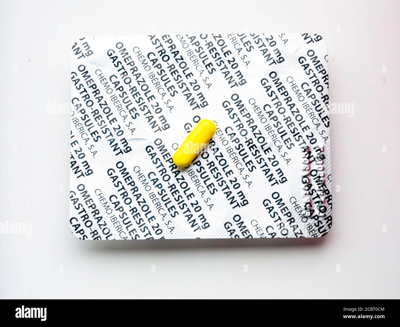 Eine Blisterpackung und eine gelbe Tagesdosis-Kapsel mit 20 mg Omeprazol Gastro-resistenten Kapseln zur Behandlung von Mageninfektionen. Stockfoto