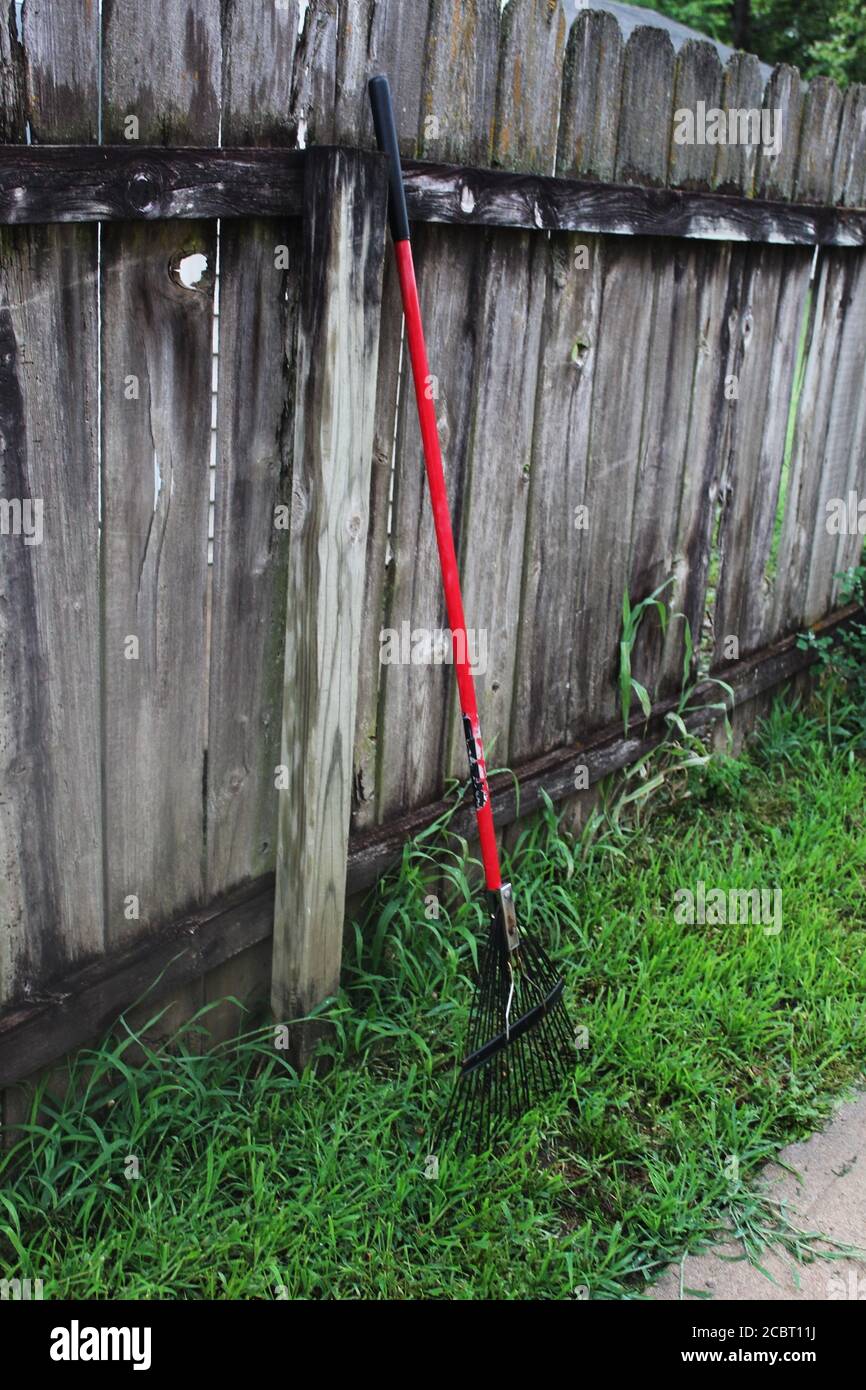 Rake schief gegen einen Holzzaun in Kansas Stockfoto