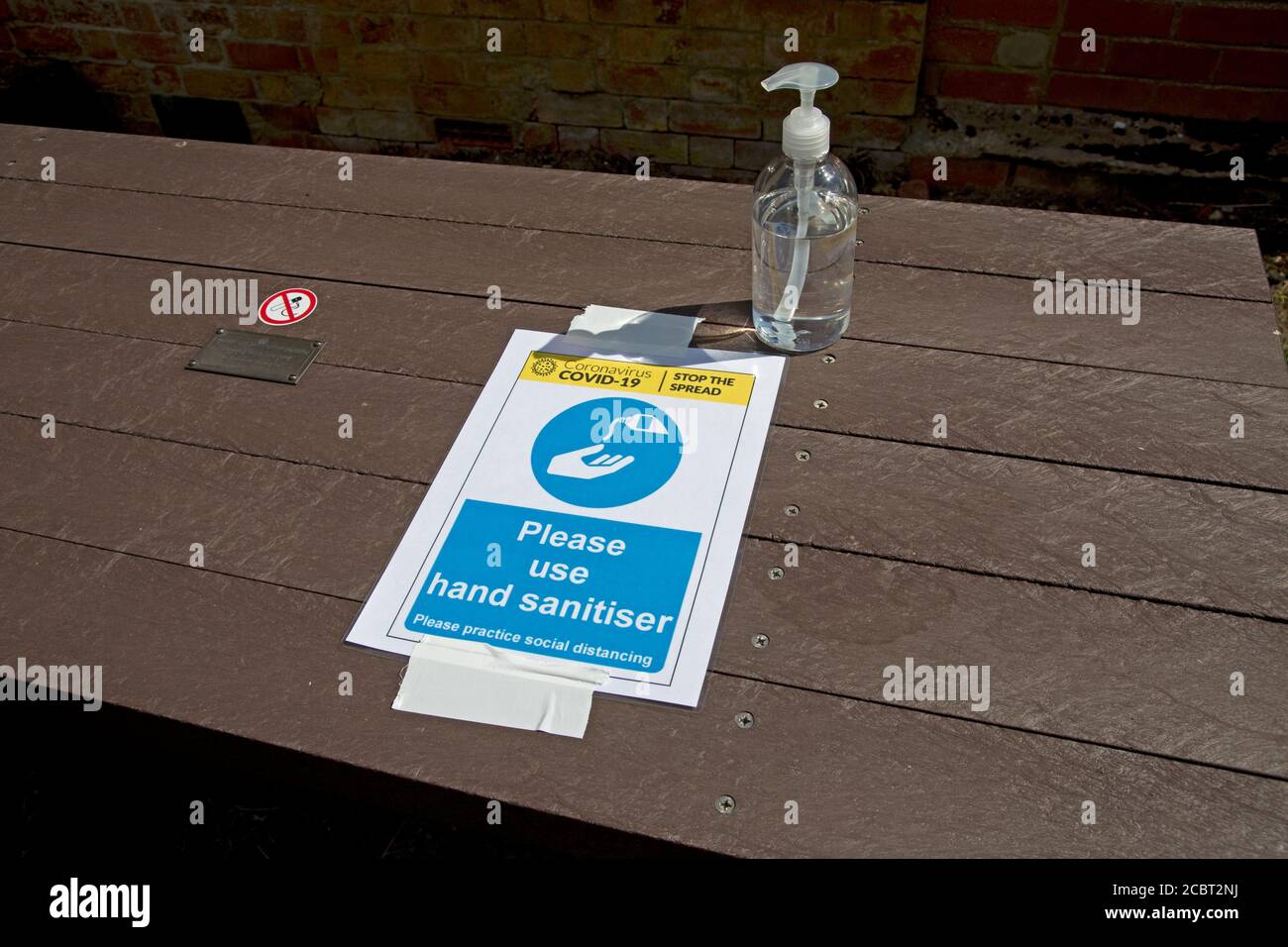 COVID 19 Hand santiser Hinweis mit Spender auf Tisch bei Open Air Kirche Service Mickleton UK Stockfoto