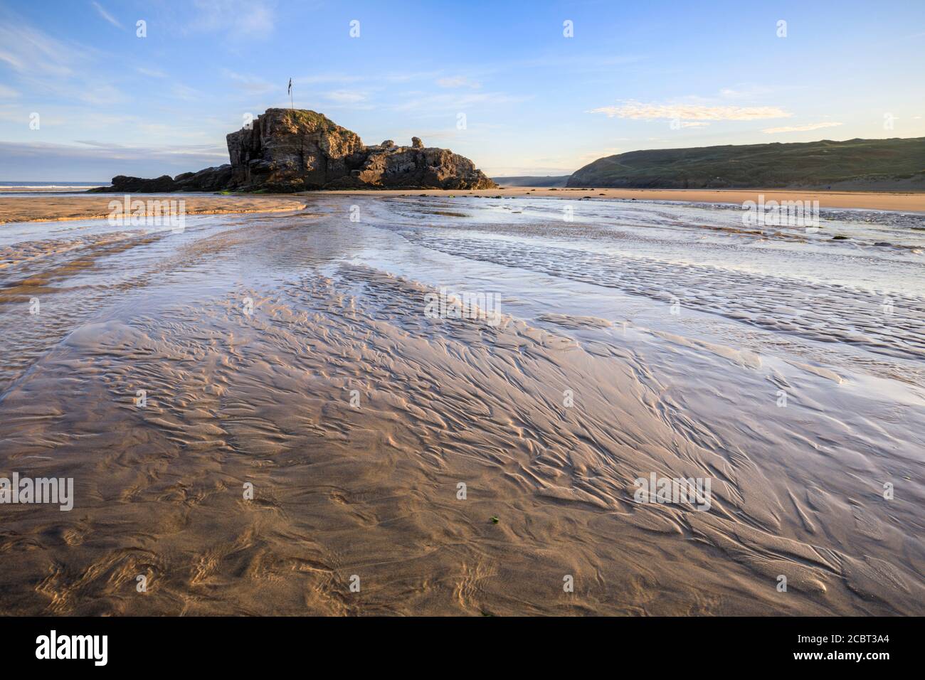 Chapel Rock am Perranporth Beach in Cornwall, aufgenommen an einem Morgen Mitte Juli mit Sandmustern als Vordergrund-Interesse. Stockfoto