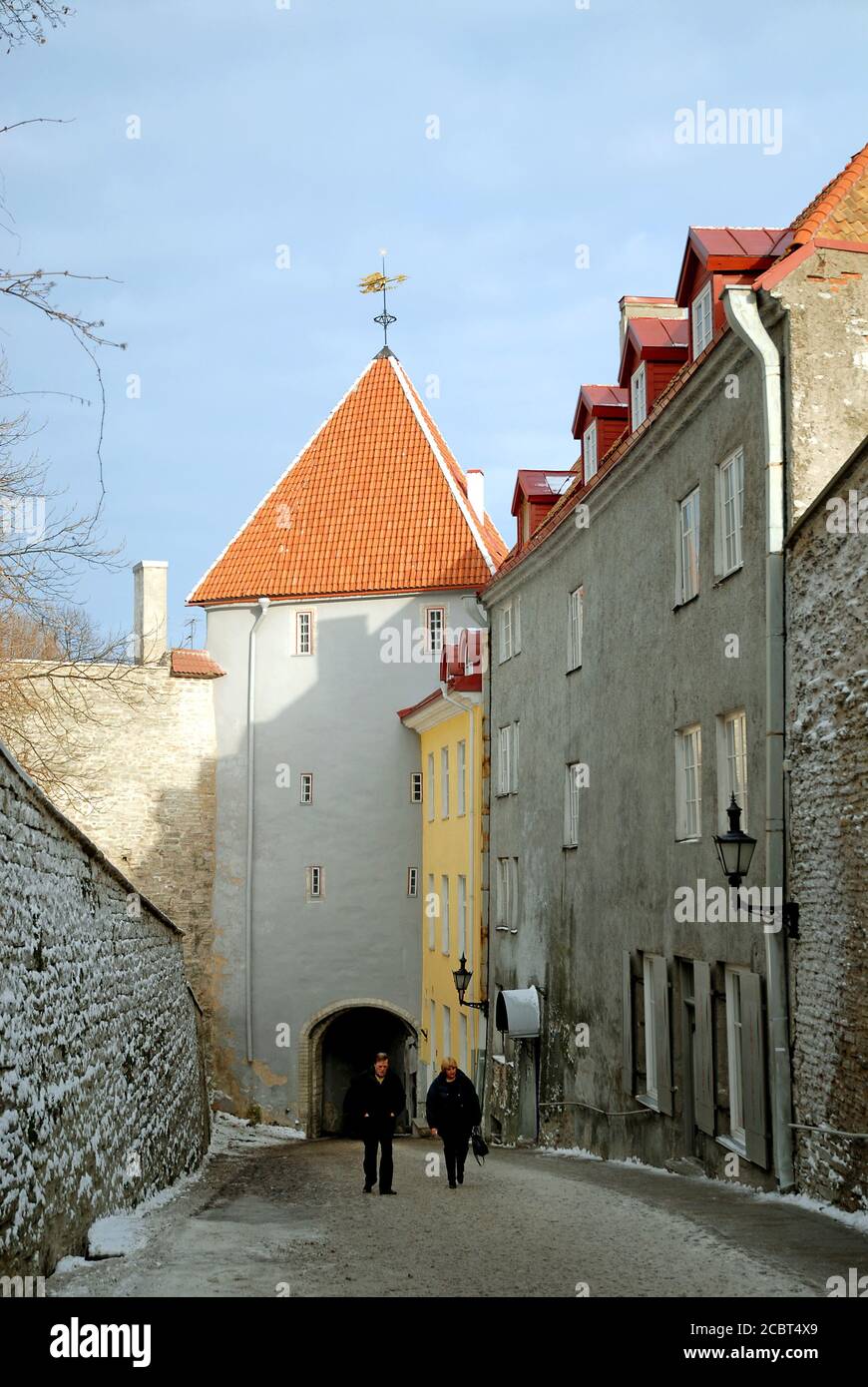 Eine Straße in der Altstadt von Tallinn mit den bunten alten Gebäuden. Zwei Menschen gehen in Tallinn, Estland, eine Straße entlang. Stockfoto
