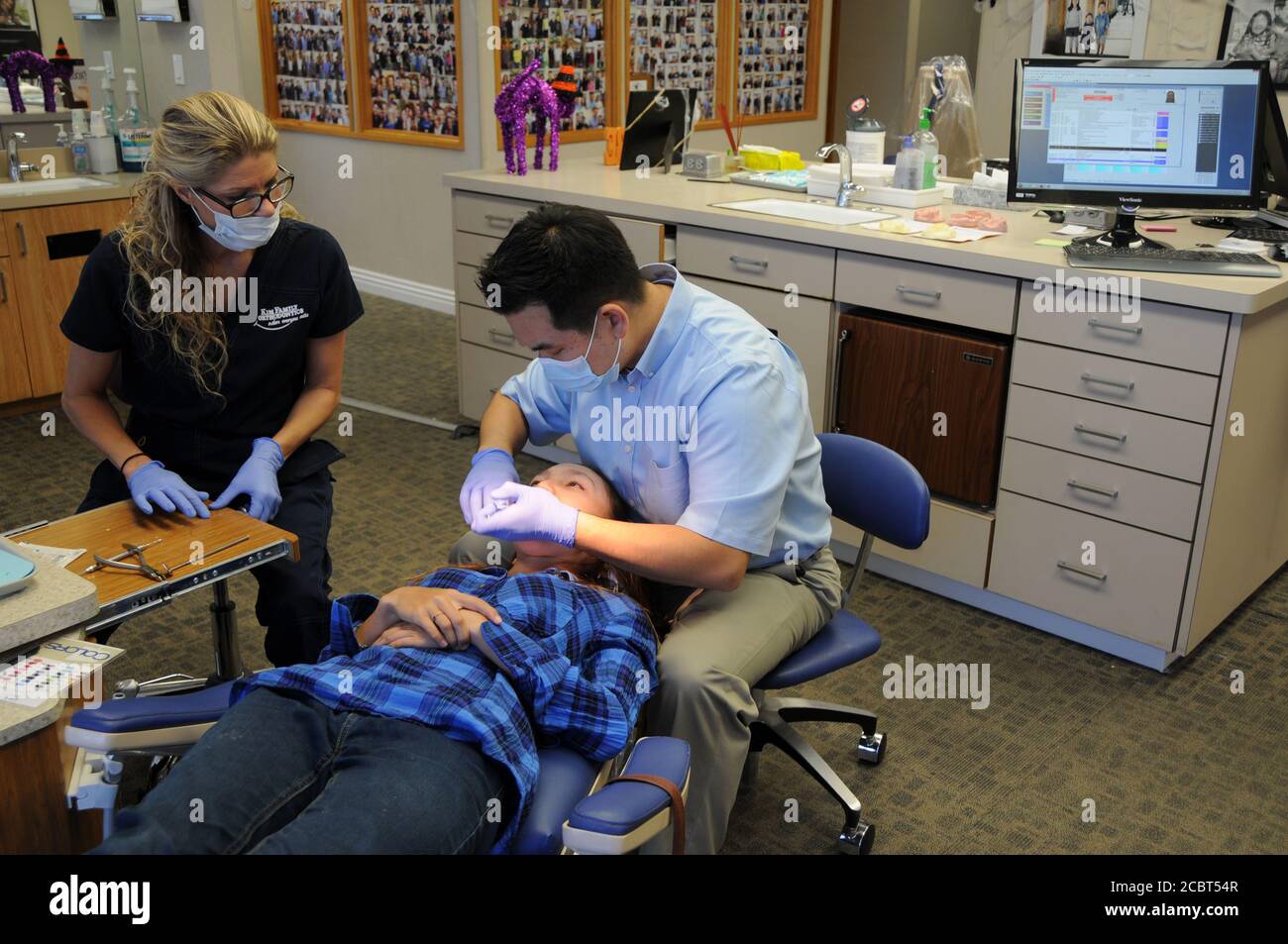 Ein Kieferorthopäde ist ein Zahnarzt, spezialisiert auf schiefe Zähne begradigen. Hier mit Assistenten und Patienten. Stockfoto