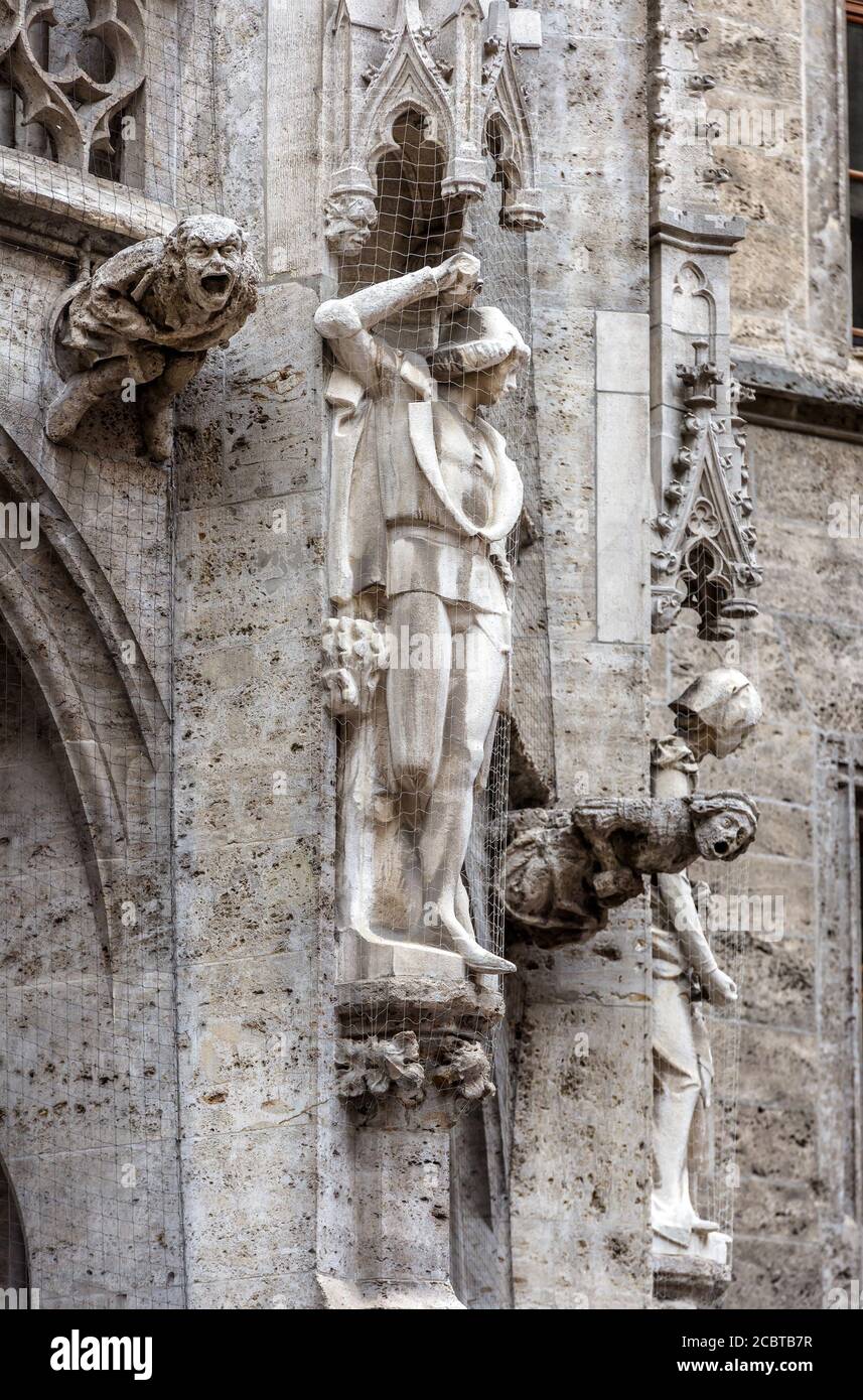 Rathaus aus der Nähe in München, Deutschland, Europa. Detail gotischer Baumauer mit Statuen und Wasserspeier im alten Münchner Stadtzentrum. Mari Stockfoto