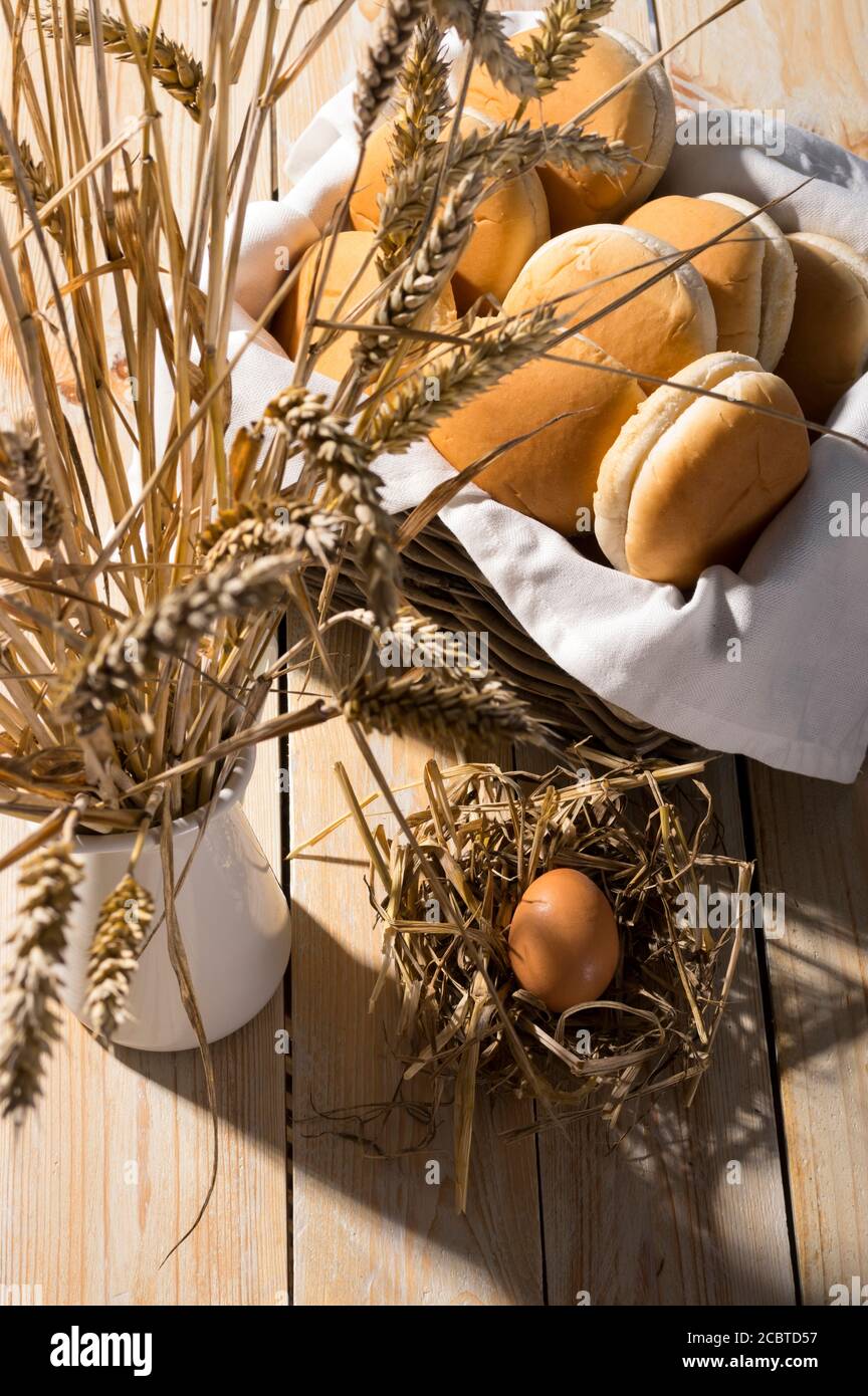 Frische, weiche Brioche-Brötchen in einem Korb auf Holzhintergrund. Scharfes Licht für sonnige Sommer Erntestimmung. Stockfoto