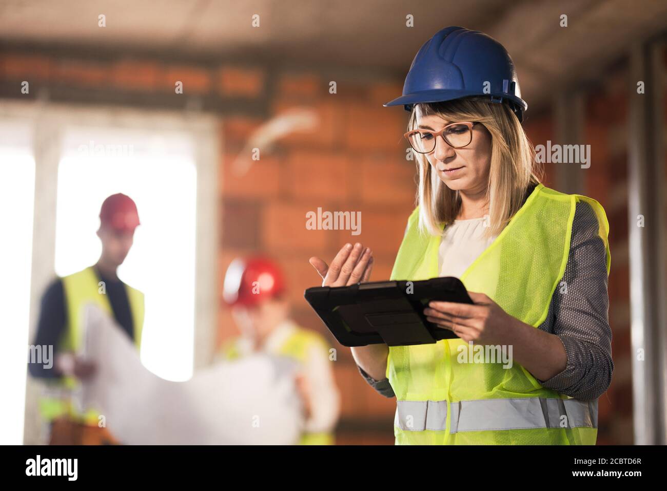 Arbeiter, Investor, Inspektor oder Architekt mit Tablet. Baustelleningenieure vor Ort. Stockfoto
