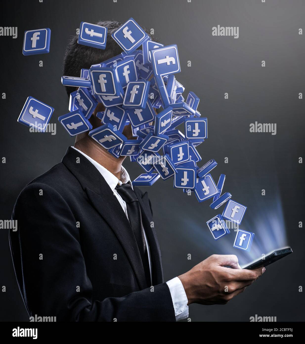 Facebook-Suchtkonzept. Businessman Open Phone Facebook Icons Pop up to the face. Stockfoto