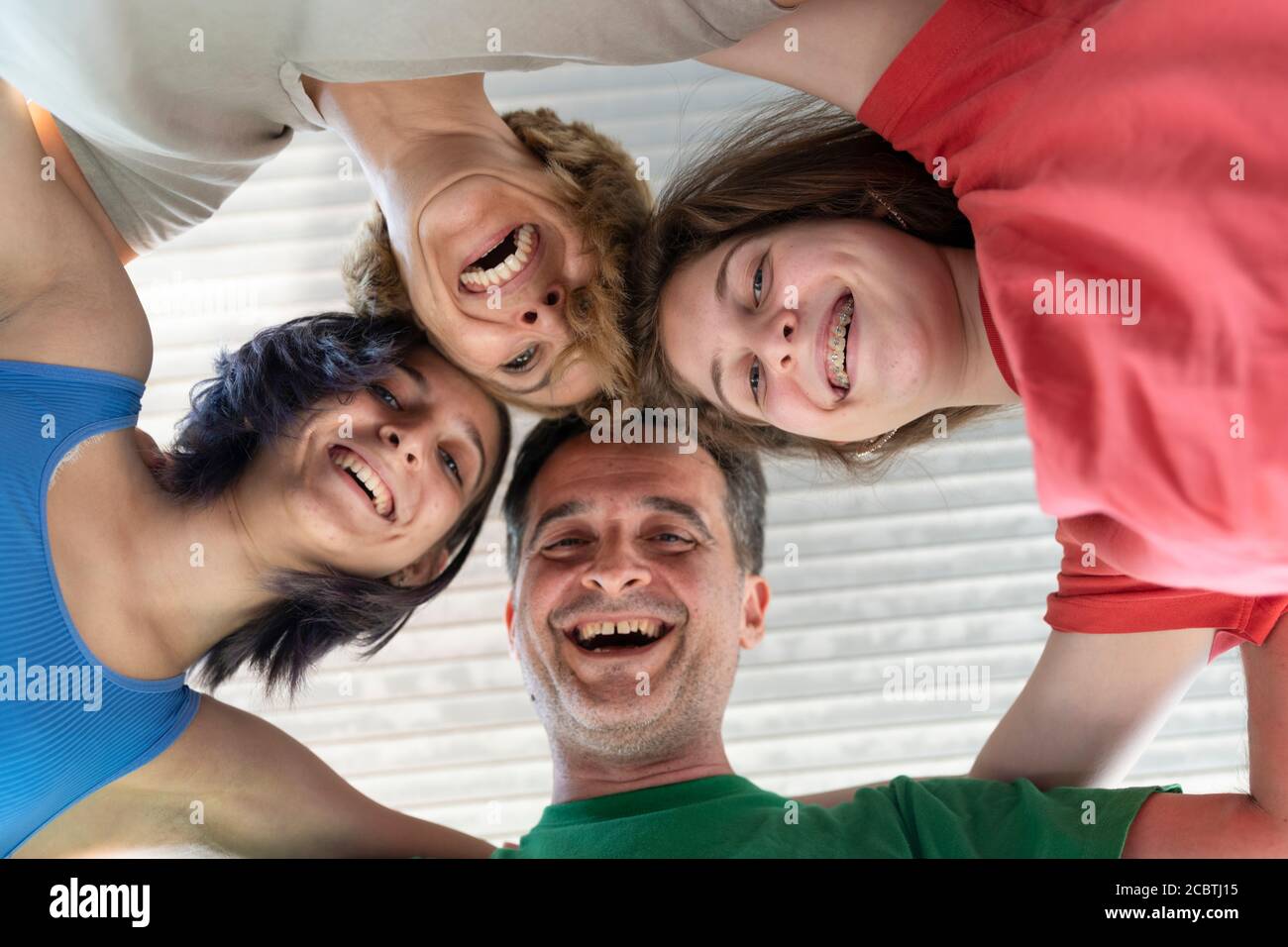 Familie lachen und Spaß zusammen haben. Low Angle Ansicht einer Familie mit ihrem Kopf bilden einen Kreis Stockfoto