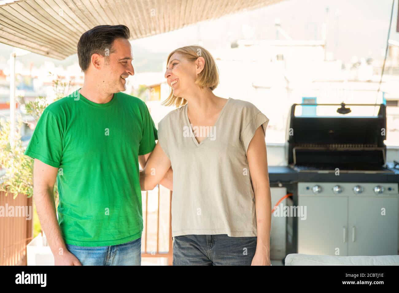 Ehepaar mittleren Alters, Mann und Frau, reden und lachen auf dem Balkon. Mann und Frau gute Beziehung Konzept Stockfoto