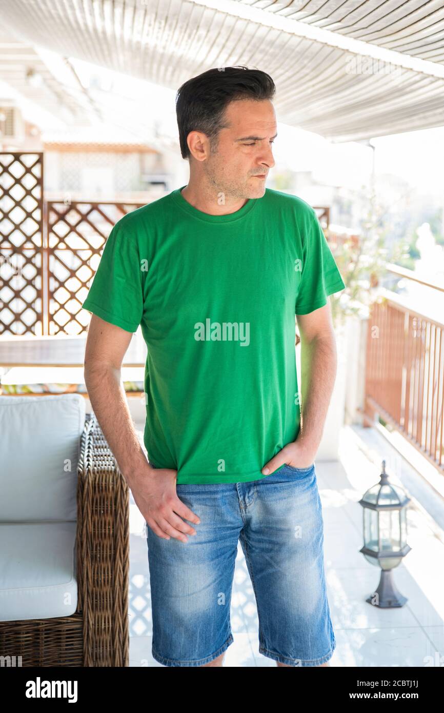 Mann mittleren Alters, der im Freien steht. Allein Konzept auf dem Balkon Stockfoto