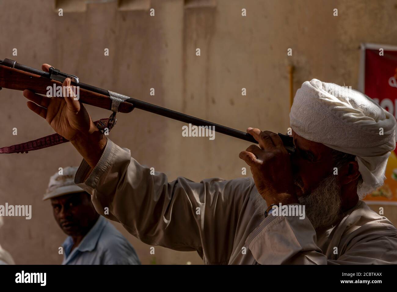 Ein omani überprüft eine Waffe auf die Straße Gewehr Anbieter Stockfoto