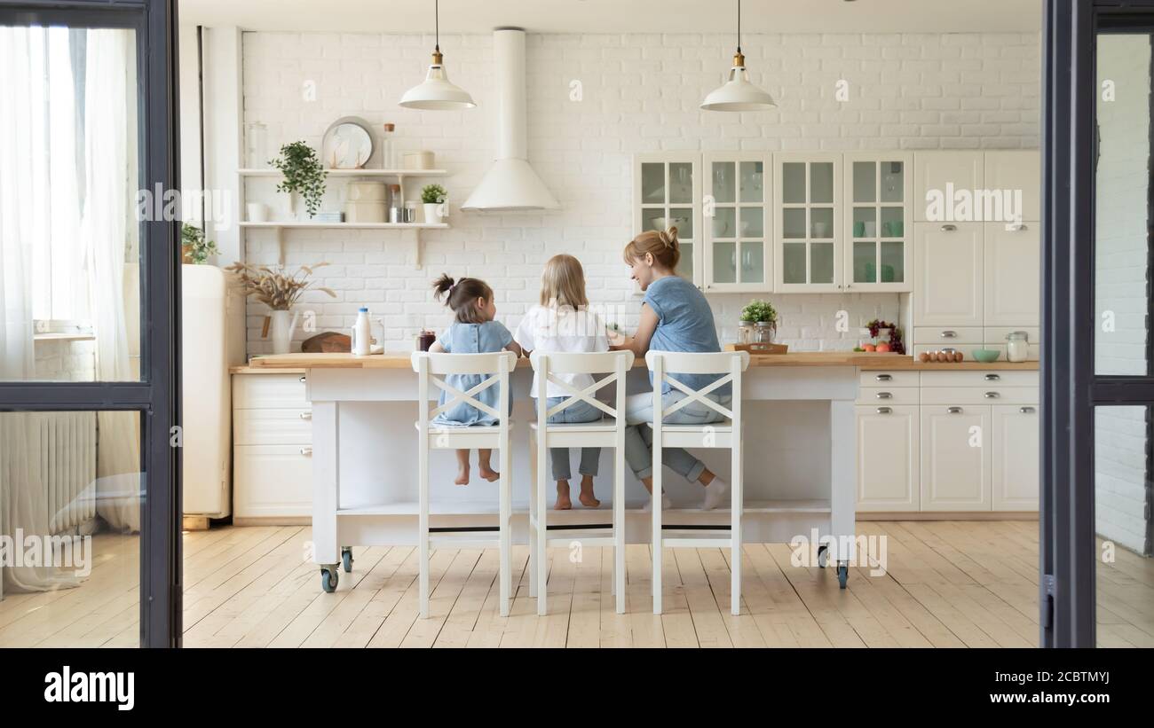 Rückansicht von Mutter und zwei kleinen Töchtern beim Frühstück Stockfoto