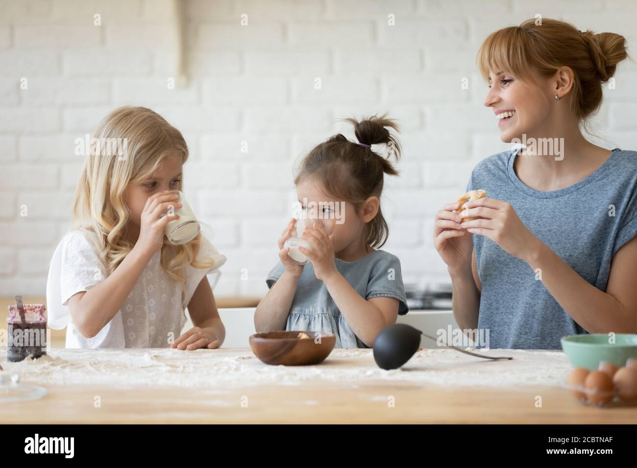 Glückliche Familie von Mutter und zwei Töchter essen hausgemachte Bäckerei Stockfoto