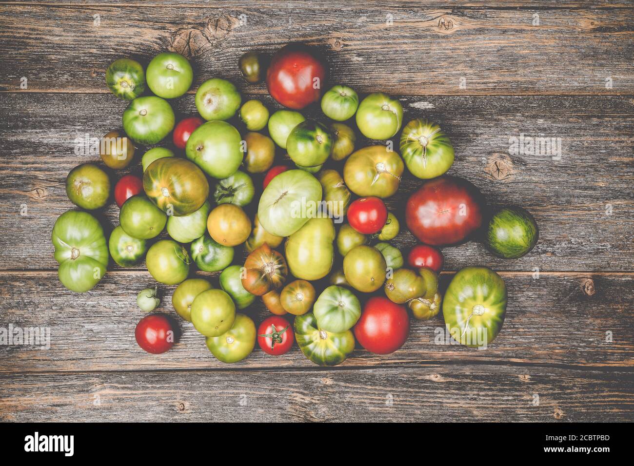 Haufen von verschiedenen Arten von Tomaten auf einem Holztisch Stockfoto