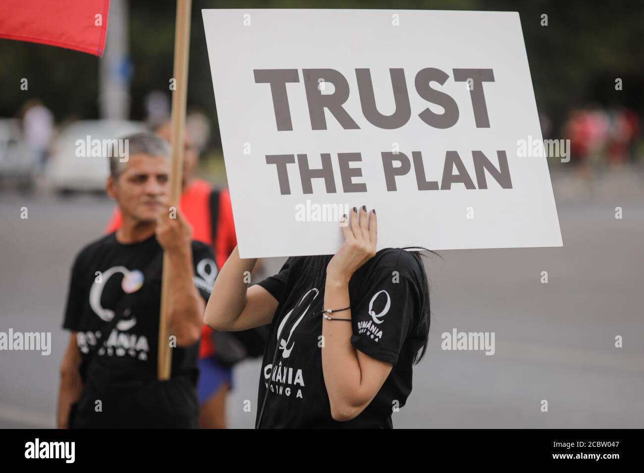 Bukarest, Rumänien - 10. August 2020: Während einer politischen Kundgebung zeigen die Menschen Qanon-Botschaften auf Kartons. Stockfoto