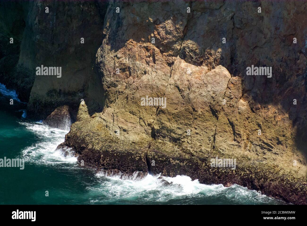 Herrliche bunte raue strukturierte Felsen und fließendes Wasser an der Basis mit Kopieplatz. Stockfoto