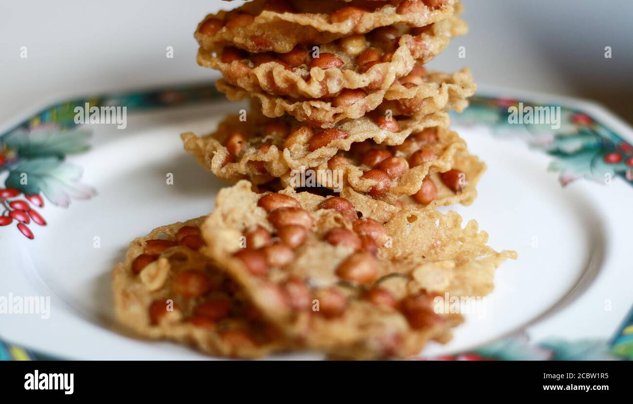 Erdnuss Peyek auf Teller. Peyek oder Peyek ist ein herzhafter javanesischer Cracker aus Reismehl mit Erdnuss. Stockfoto