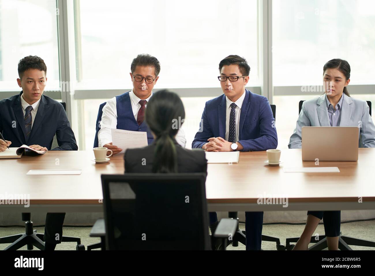 Junge asiatische Arbeitssuchende wird von einer Gruppe von interviewt Führungskräfte in Unternehmen Stockfoto