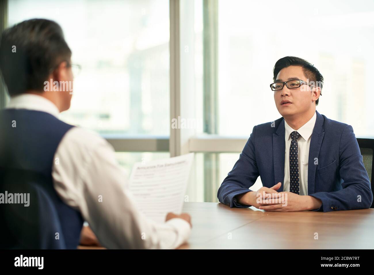 Junger asiatischer Mann, der vom Personalmanager des Unternehmens interviewt wird Stockfoto