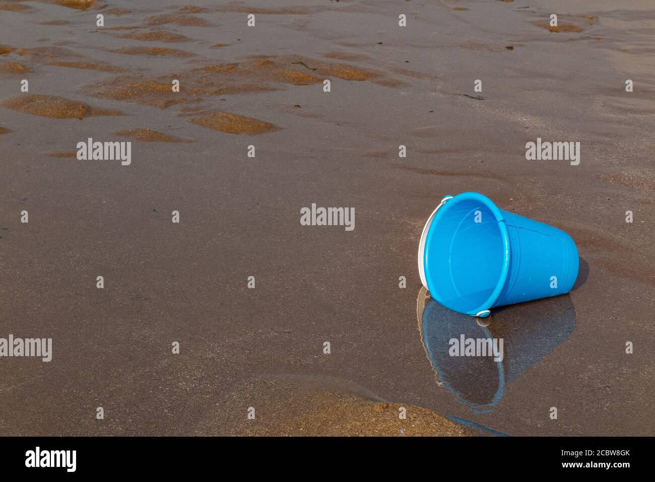 Ein Plastikeimer eines Kindes, der an einem Strand aufgegeben wurde Stockfoto