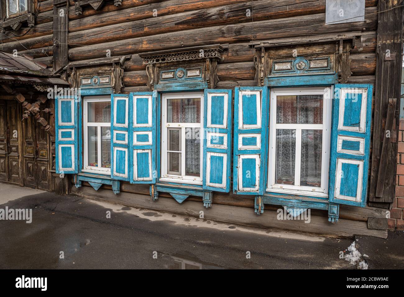 Fenster mit blauen Fensterläden eines traditionellen Holzhauses in Irkutsk, Russland Stockfoto