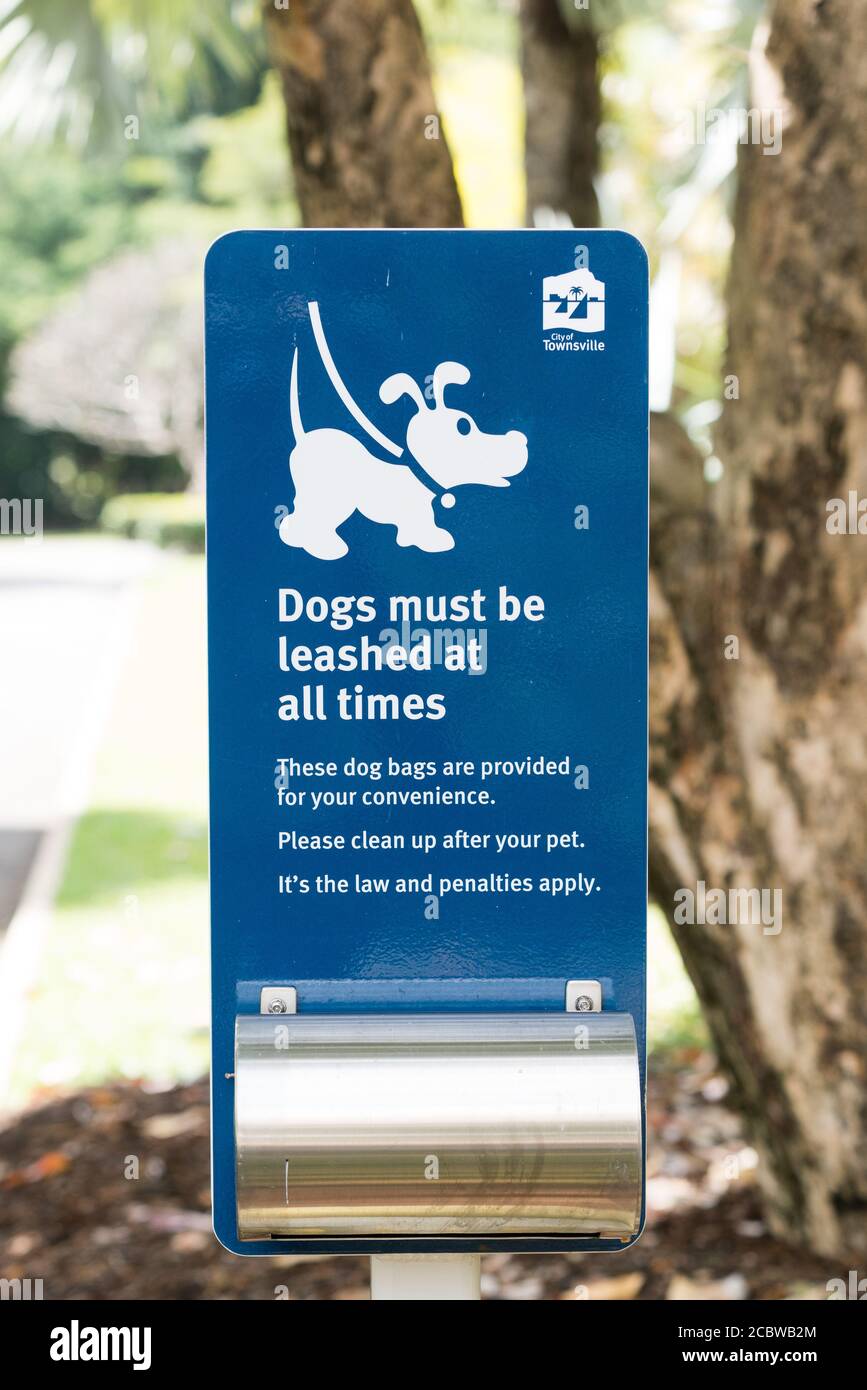 Unterschreiben Sie, um Hunde an der Leine zu halten und kostenlose Wurftaschen, um nach Ihrem Haustier, Townsville, Australien, aufzuräumen Stockfoto