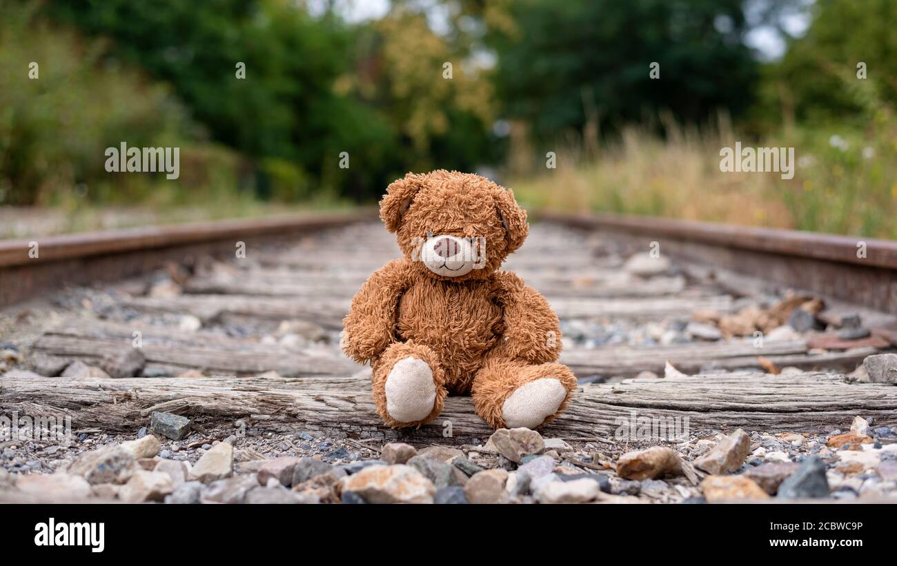 Einsamer Teddybär auf den Schienen der stillgelegten Eisenbahnen verlassen. Stockfoto