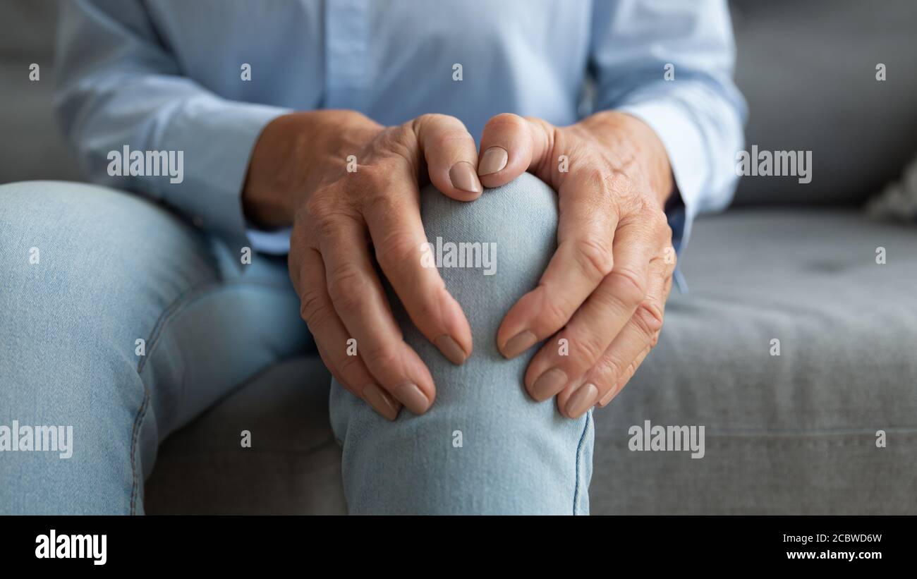 Nahaufnahme reife alte Frau berühren Kniegelenk. Stockfoto