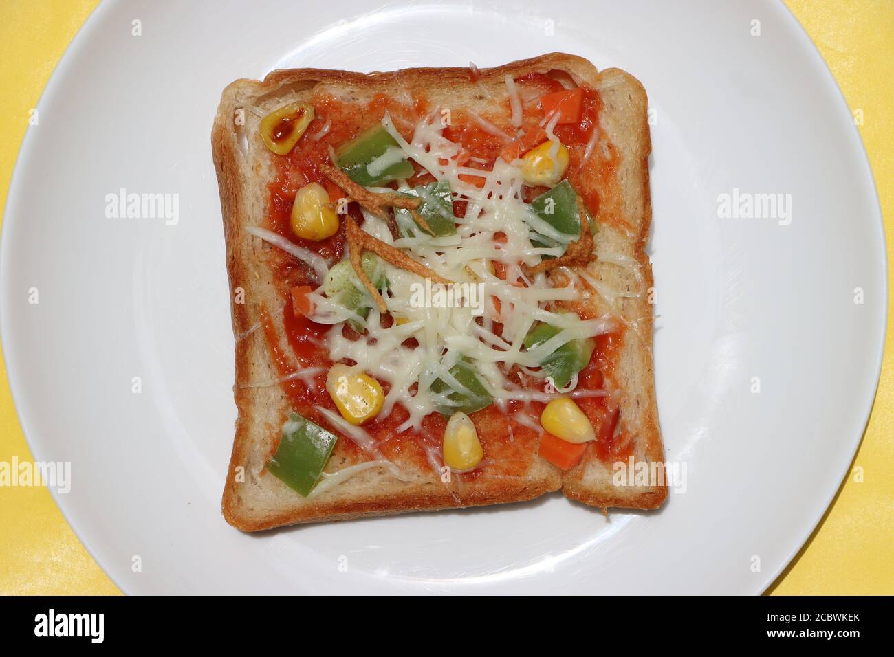 Brownbread Pizza, gekrönt mit Mais, Gemüse und Käse, Kinder-Frühstück, indische Street Food Stockfoto