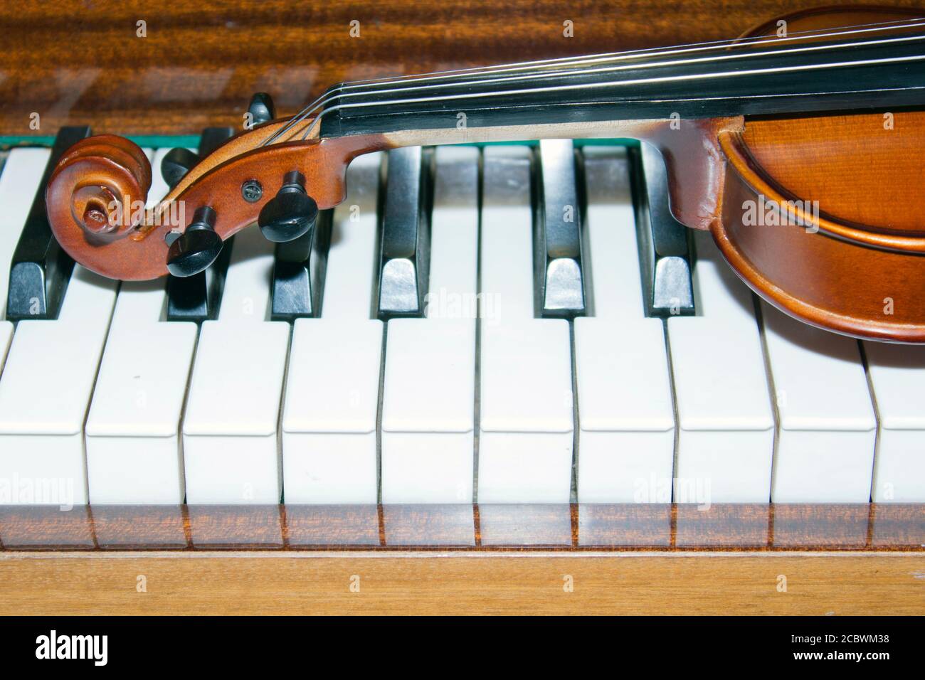 Sehr alte Geige, liegend auf dem Klavier Stockfoto