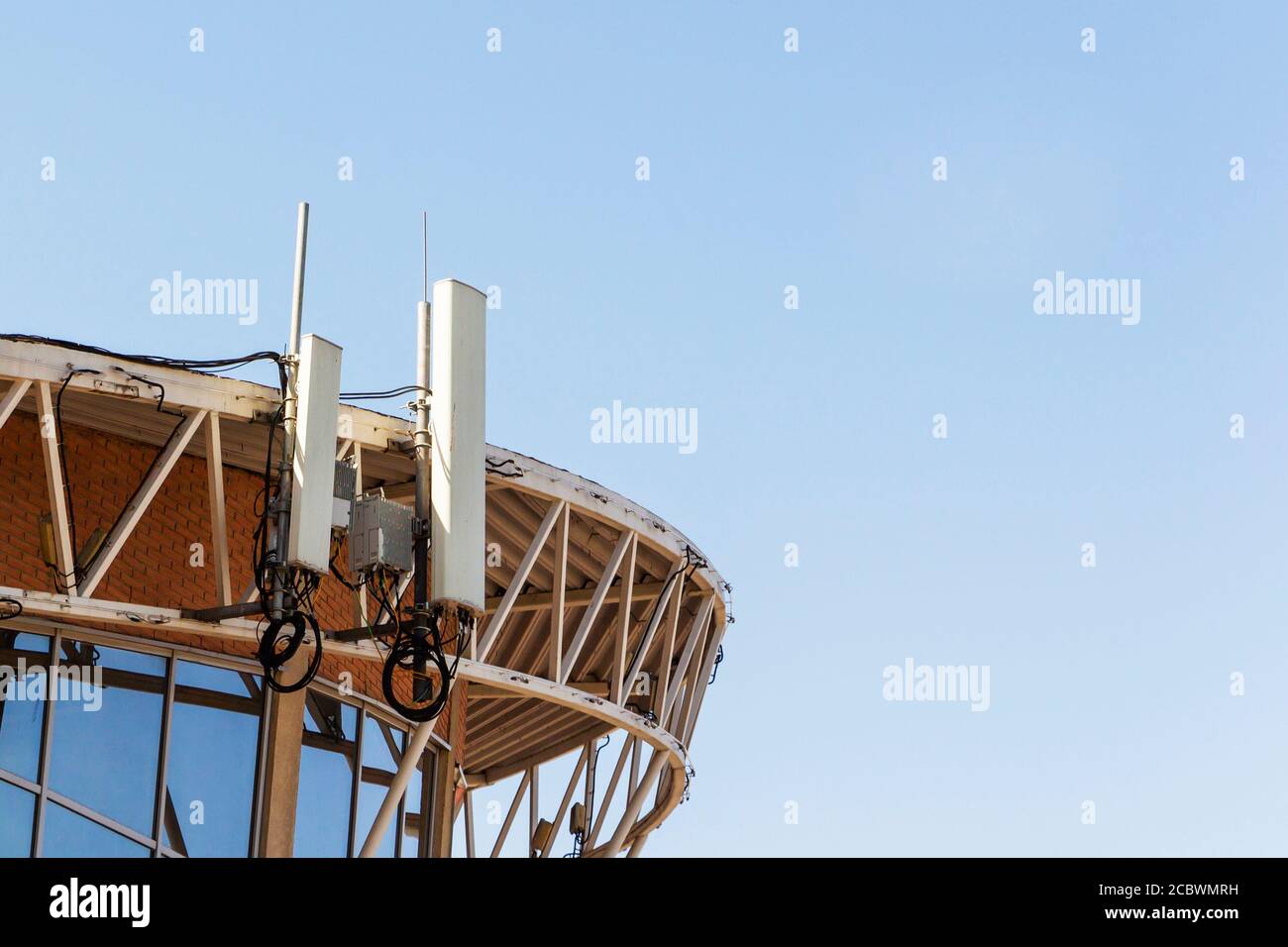 Mobilfunkantenne auf dem Dach des Gebäudes gegen die Blauer Himmel Stockfoto