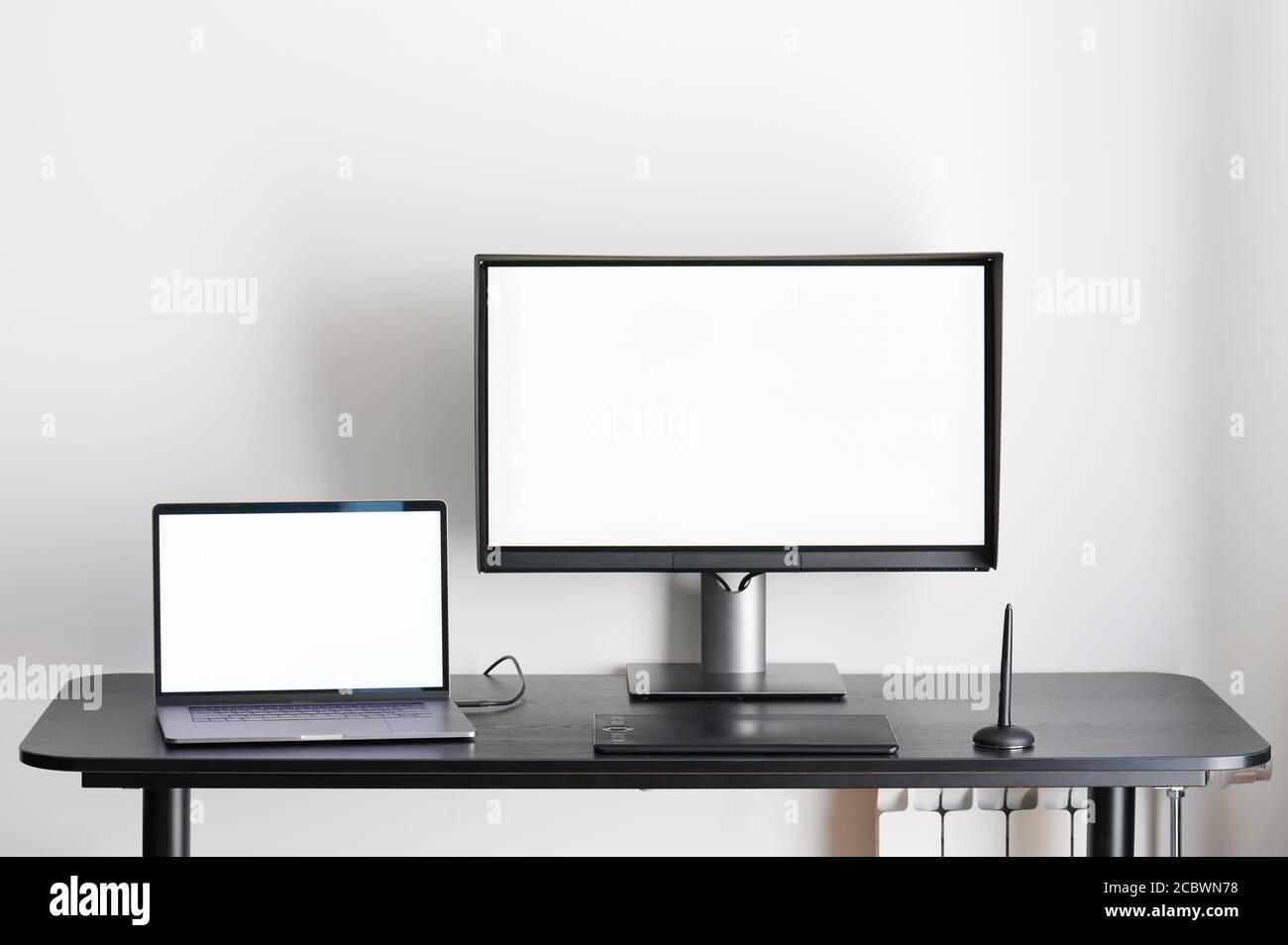 Schreibtisch mit Laptop und Computermonitor im Büro Stockfoto