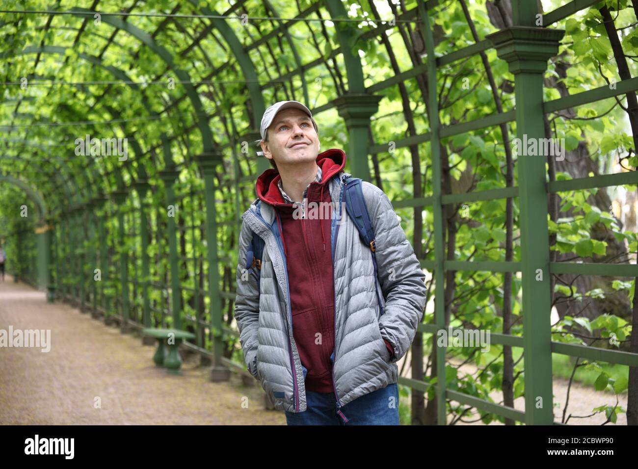 Reifer kaukasischer Mann mit Rucksack in einem Stadtgarten Stockfoto